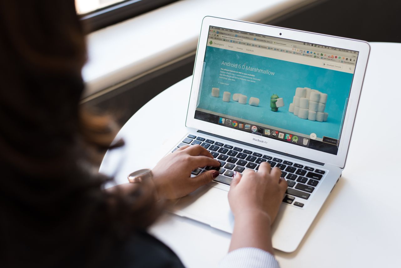 Home Businesswoman working on laptop with Android 6.0 Marshmallow webpage open.