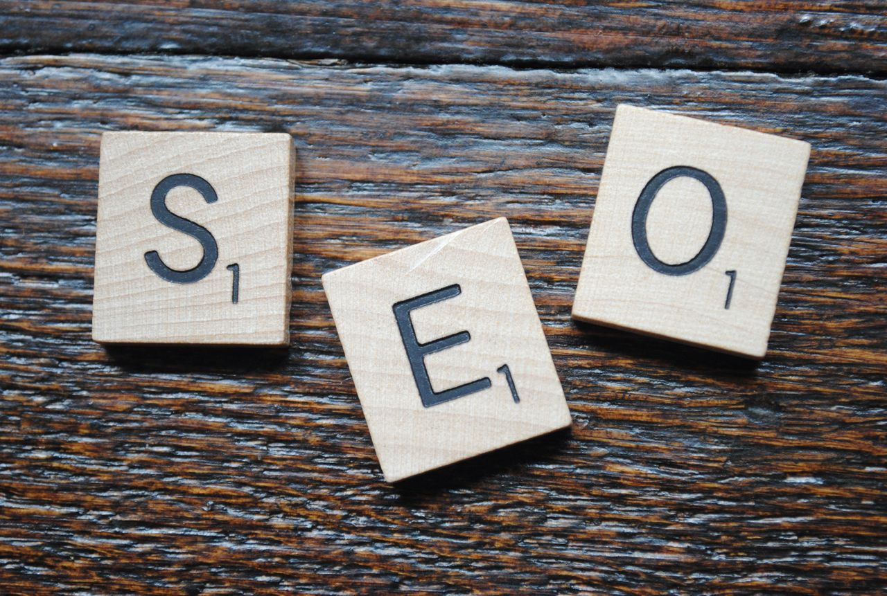 Home Close-up of Scrabble tiles spelling SEO on a wooden table for content strategy.